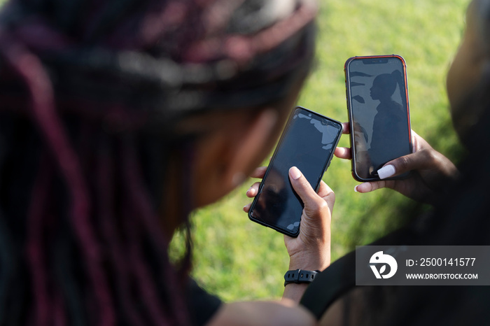 Close-up of female friends holding smart phones