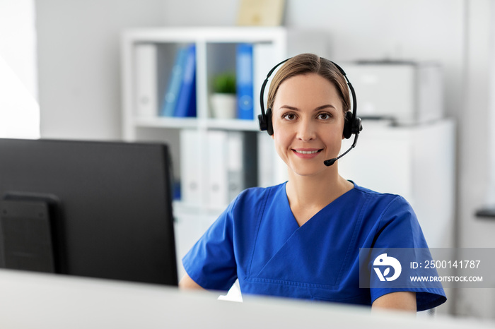 medicine, technology and healthcare concept - happy smiling female doctor or nurse with headset and computer working at hospital