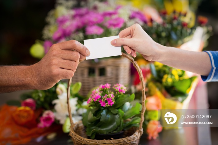 Florist giving visiting card to customer