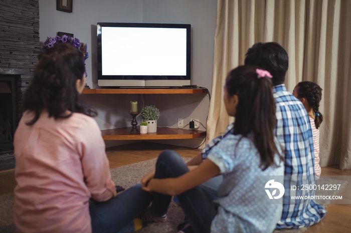 Family watching television together in living room