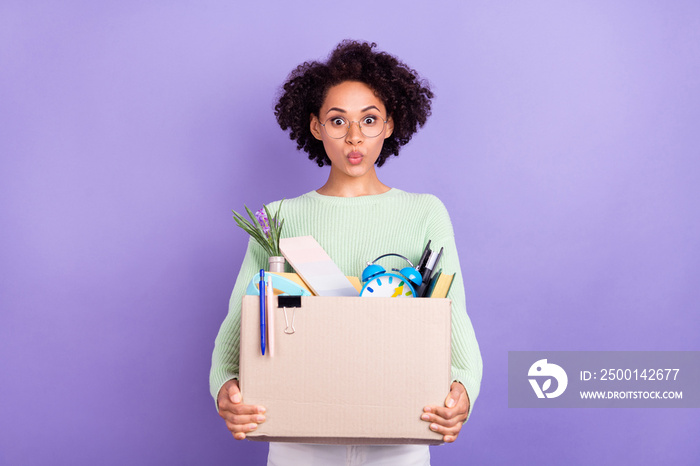 Photo of young amazed dark skin shocked woman hold hands box college move isolated on violet color background