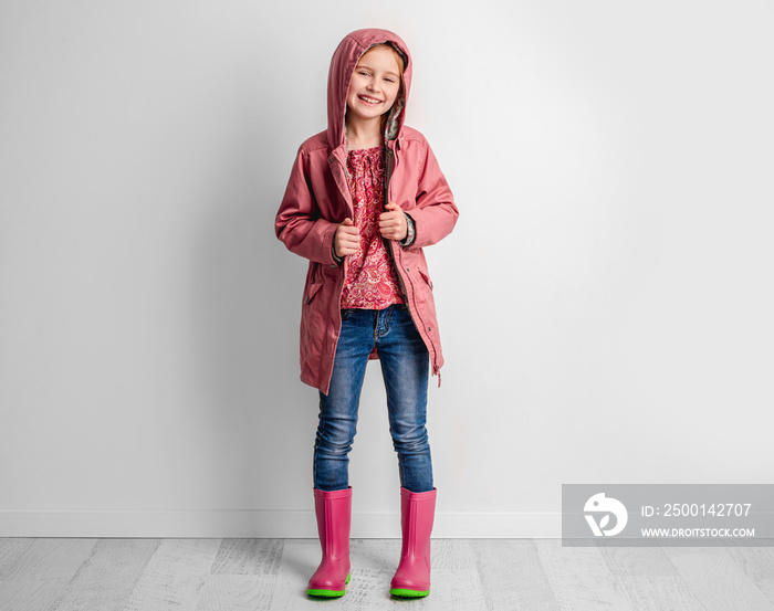 Little girl wearing raincoat and rubber boots