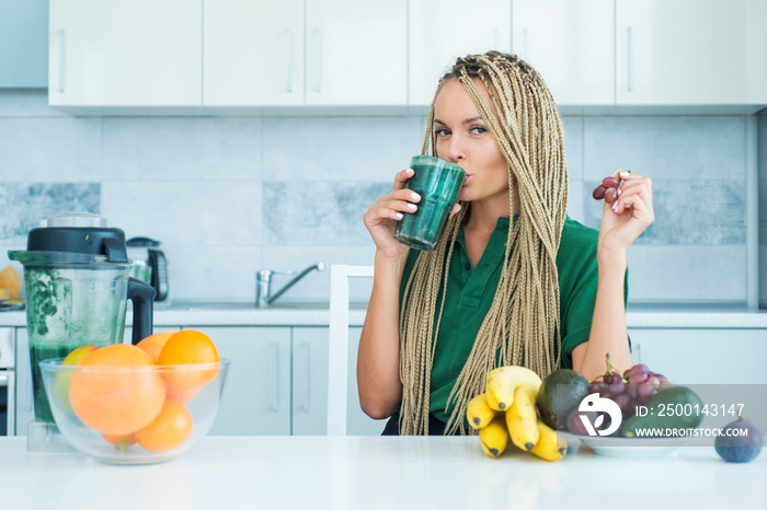 Detox. Female hand holding glass of fresh organic green smoothie with spinach. Fitness and dieting. organic food and vitamin. Athletic young woman with protein shake in kitchen.