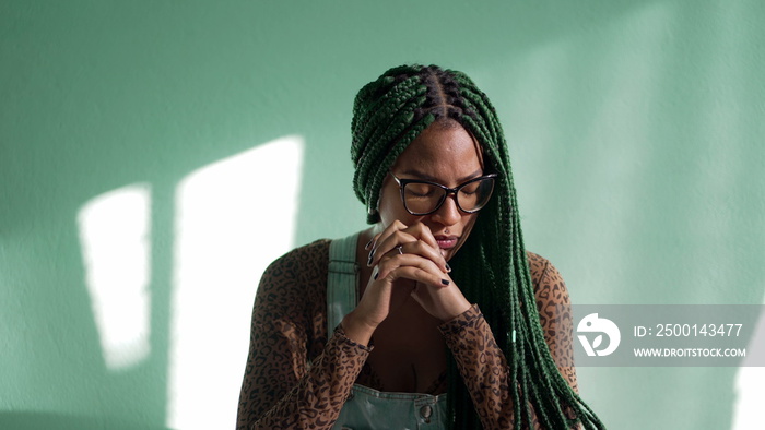 Preoccupied young African American adult girl with box braids. One worried stressed thoughtful female black girl reflecting decision. Dilemma emotion