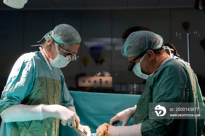 Open heart surgery, doctors and cardiologists perform open heart surgery. Doctors in green uniforms in the operating room.