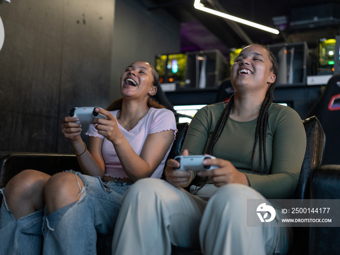 Female friends playing video games in gaming club