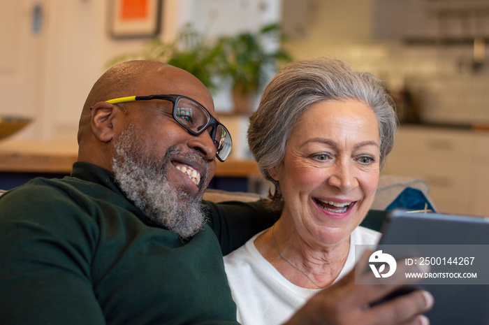 Senior couple using digital tablet at home