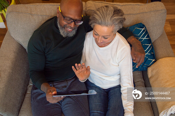 Senior couple using digital tablet at home