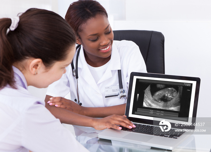 Doctor Showing Ultrasound Scan Of Baby To Her Patient