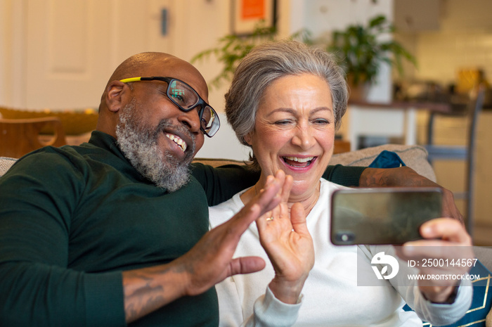 Senior couple using smart phone at home