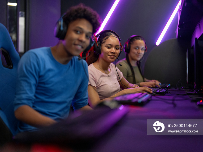 Portrait of friends playing video games in gaming club