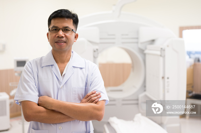 Asian radiologists shows sitting on the chair and the patient CT scan image at display for planing treatment background in x-ray room.High technology for medical treatment equipment concept.