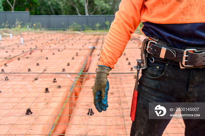 Australian steel fixing worker equipped with tools standing on construction site on a day