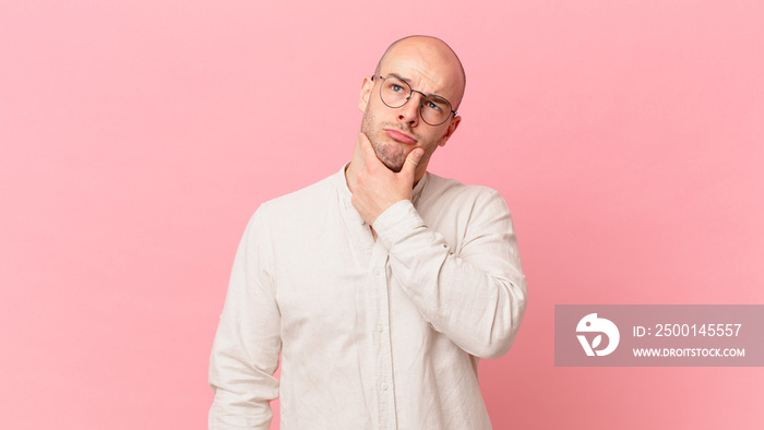 bald man thinking, feeling doubtful and confused, with different options, wondering which decision to make