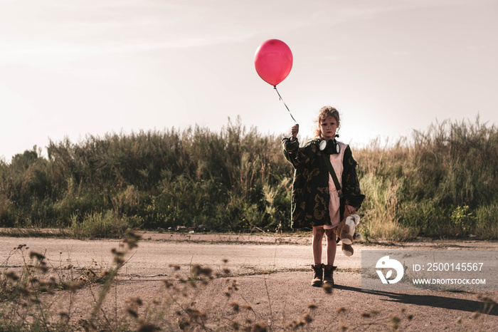 selective focus of cute kid with gas mask holding balloon, post apocalyptic concept