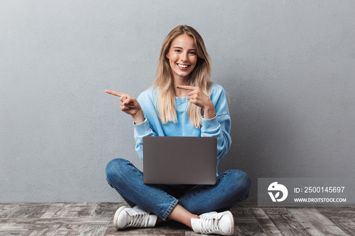 Pretty young blonde girl using laptop computer