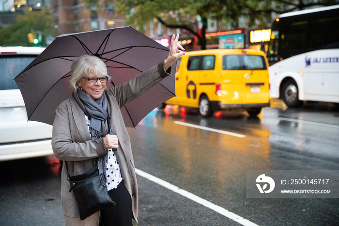 Mature senior white haired woman waiting for taxi cab in New York