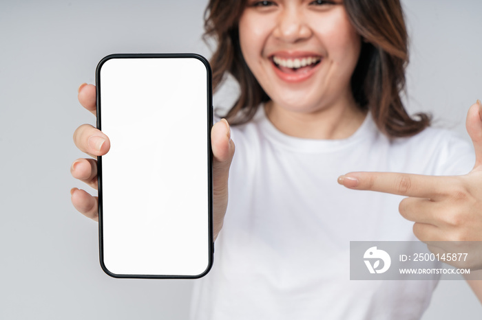 Selective focus, Smartphone blank screen with empty space for mobile app on screen on hand cheerful Asian woman.