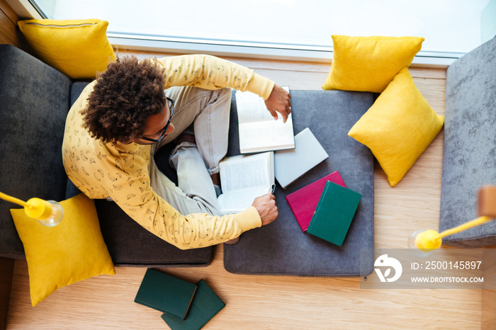 African young man studying and reading books at home