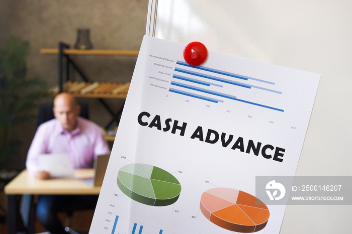 Business concept about CASH ADVANCE with inscription on the financial document. Businessman working with documents in the background.