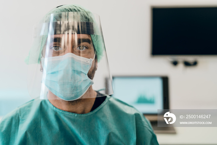 Doctor wearing ppe face surgical mask and visor fighting against corona virus outbreak - Health care and medical workers concept