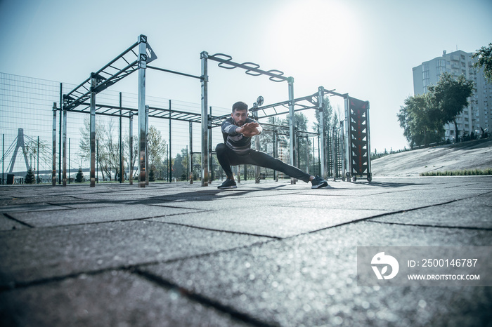 Confident sportsman doing morning exercises while being at the sports ground