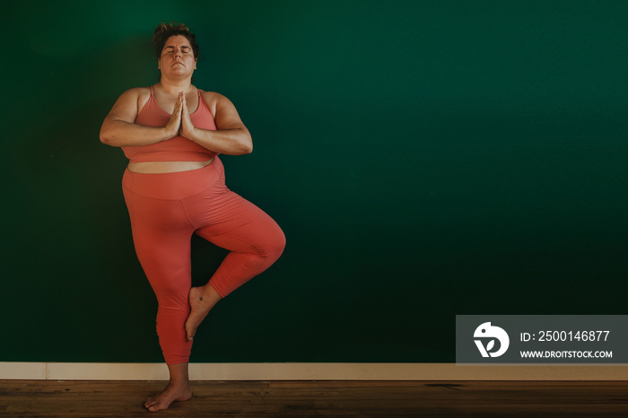 portrait of a plus size woman doing yoga