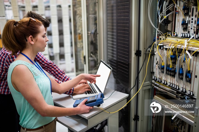 Technicians using laptop while analyzing server