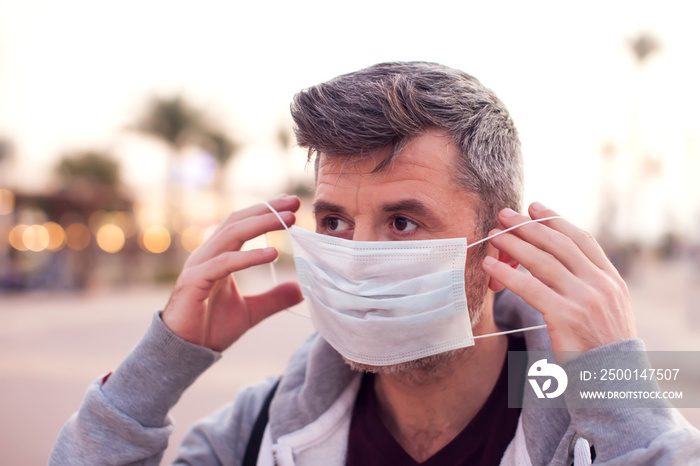 A portrait of man with medical face mask outdoor. People, medicine and healthcare concept