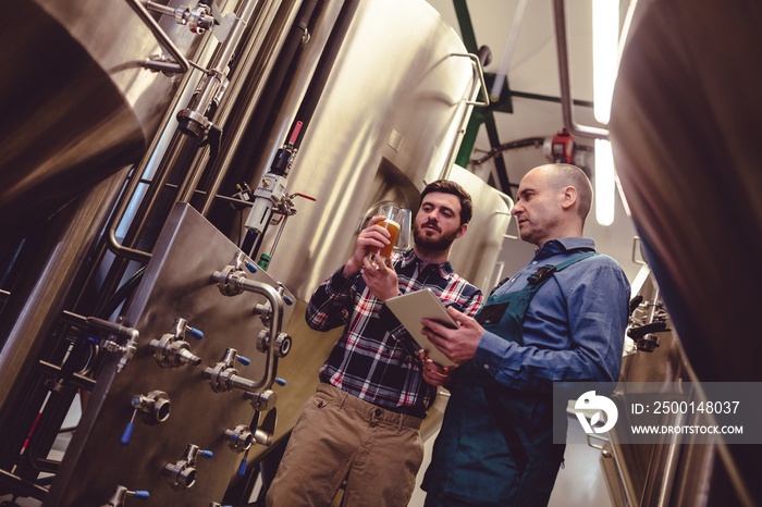 Worker and owner discussing over beer in container