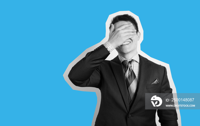 Young businessman in suit on gray background face palm and smiling.