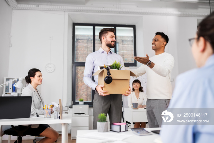 business, new job and corporate concept - male employee with personal stuff meeting colleagues at office