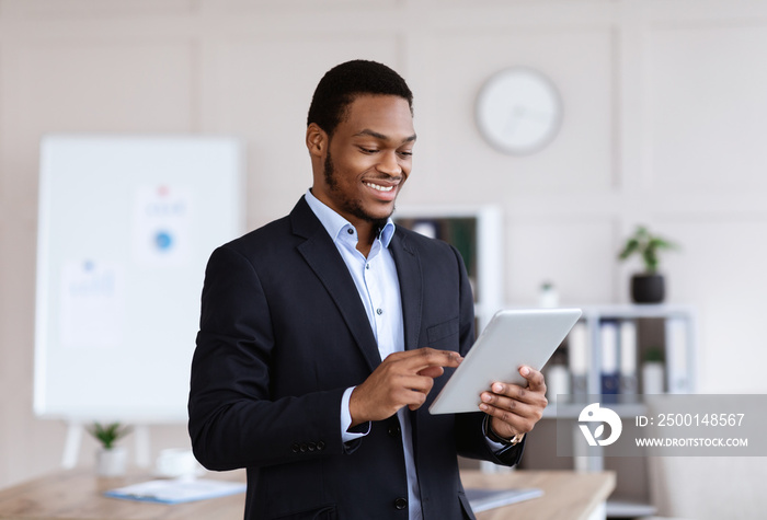 Happy african american businessman using digital tablet