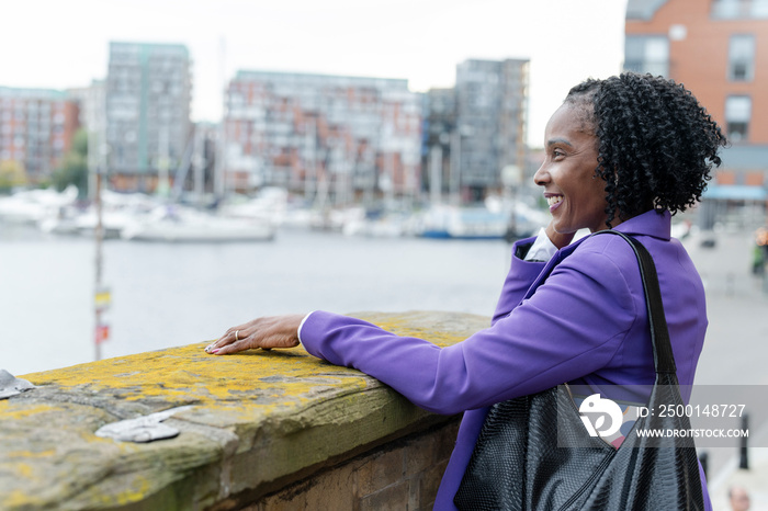 Thoughtful woman looking at river in city