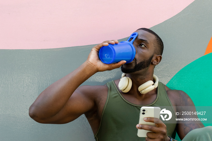 Mid adult man drinking water from plastic container