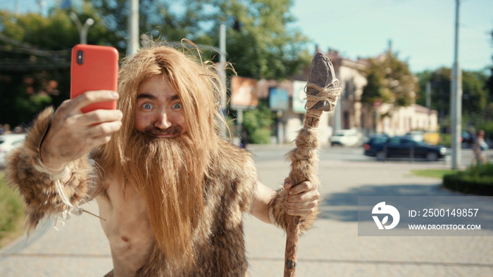 Prehistoric tribesman of neanderthals noticing somebody hurrying taking photographs like paparazzi on future smartphone in modern civilization city.