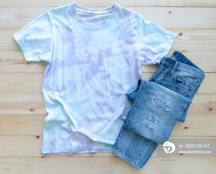 Colorful tie die tshirt and jean on wooden background. fashion summer