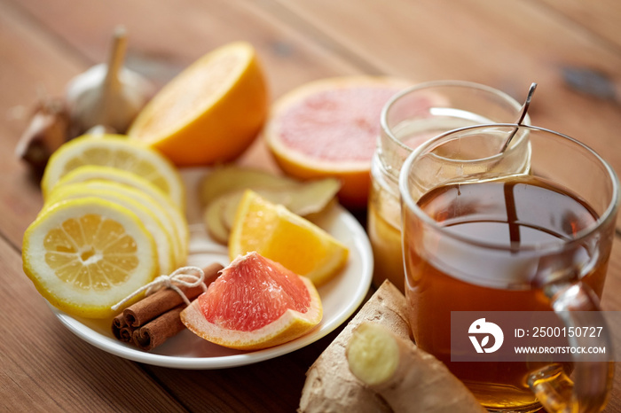 ginger tea with honey, citrus and garlic on wood