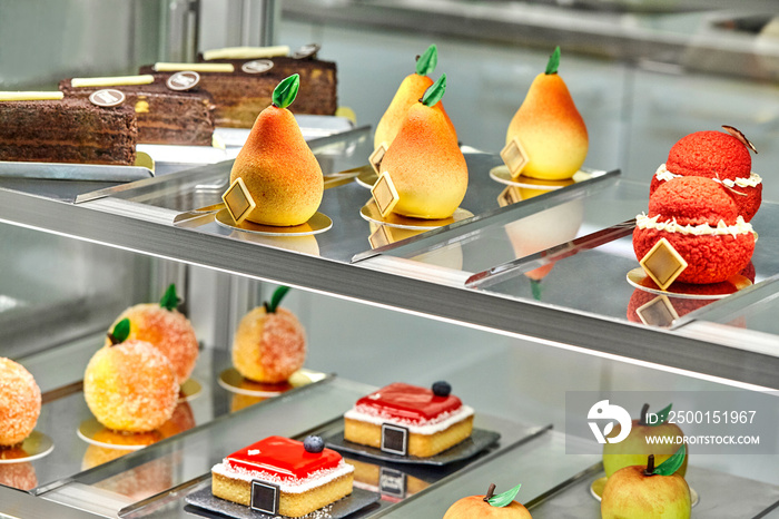 Colorful showcase of cafe with fresh sweet cakes and fruit shaped pastries