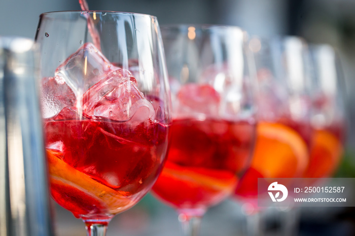 glasses of cocktails on the bar. bartender pours a glass of sparkling wine with Aperol.