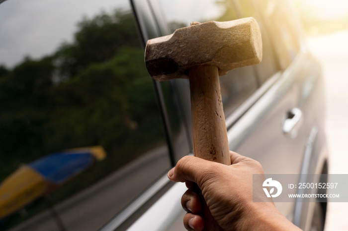 Hammer on hand to smash the car glass to prepare theft.