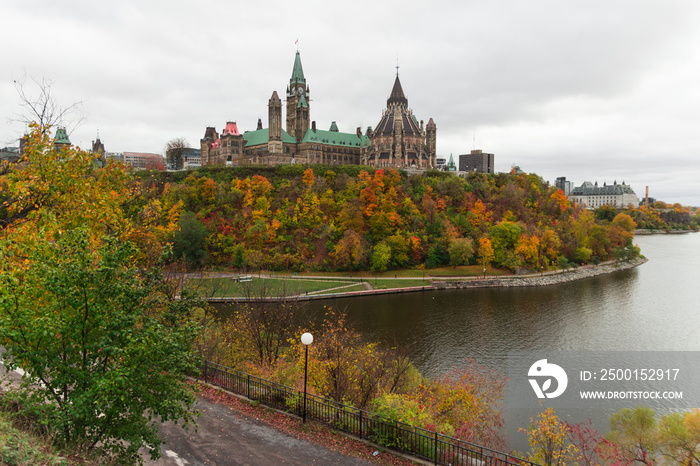 Parliament hill (Ottawa, Ontario, Canada). Beautifil wide-angle shot during the fall season. Crown land on the southern banks of the Ottawa River, downtown. Gothic revival style. Cloudy day.