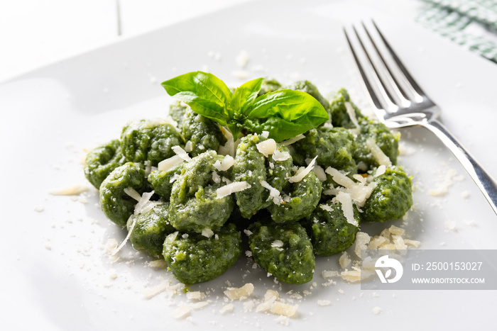 Piatto di deliziosi gnocchi di spinaci conditi con burro e formaggio, cibo italiano