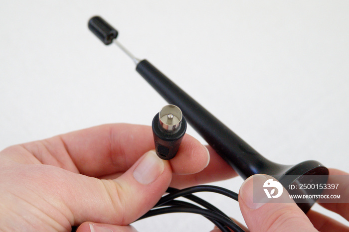 Hand holding Coaxial cable antenna connector of a DVB-T pig antenna