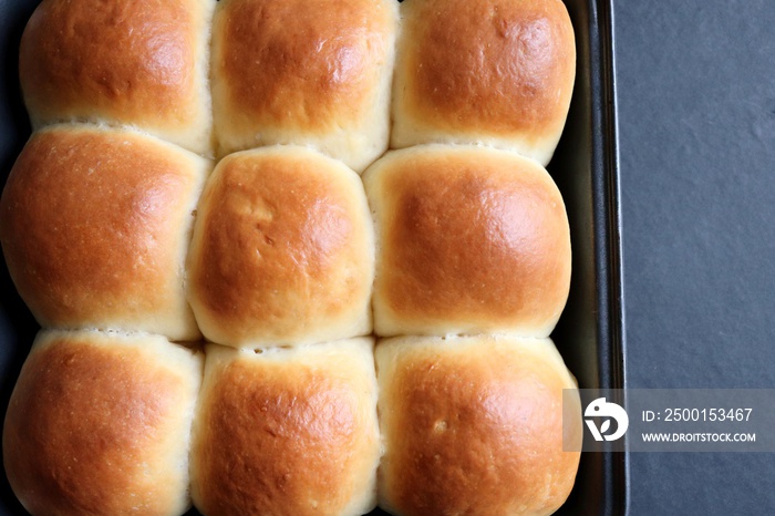 Freshly baked homemade Mumbai style golden Ladi pav or soft dinner bread roll in a baking tray. made out of all-purpose flour, yeast, milk and salt.  Ideal for pav bhaji or missal pav. Copy space.