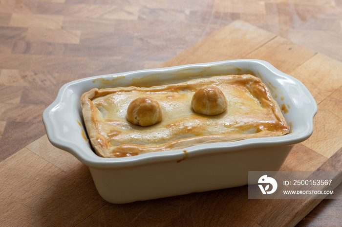 Tart or savory pie in a white dish at wooden table