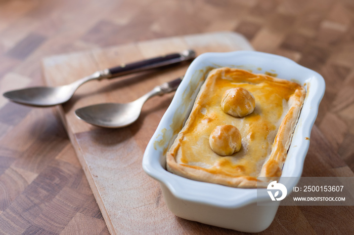 Tart or savory pie in a white dish at wooden table