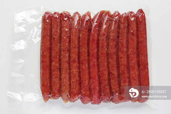 Chinese sausage in vacuum package on white table.