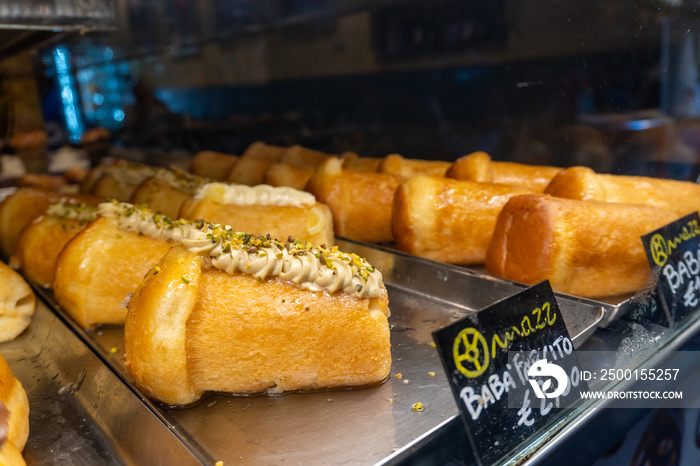 Typical Neapolitan sponge cake called Babà, in a shop window of a pastry shop in the city of Naples