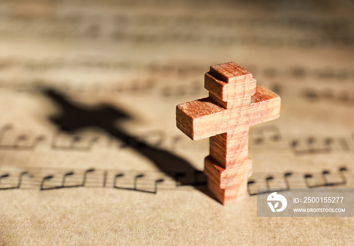 Wooden cross on music sheet